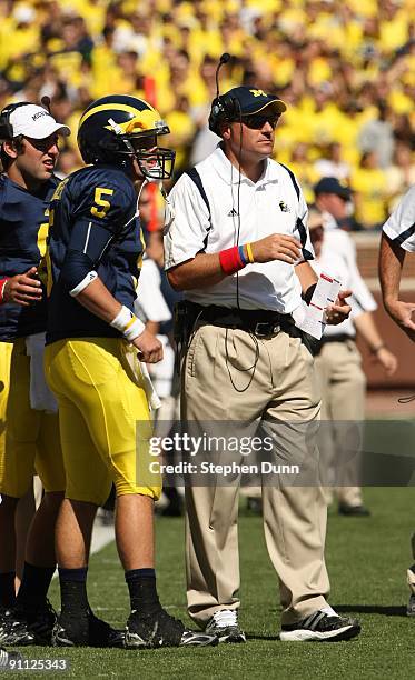 Head coach Rich Rodriguez of the Michigan Wolverines talks with quarterback Tate Forcier during the game with the Eastern Michigan Eagles at Michigan...