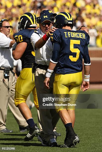 Head coach Rich Rodriguez of the Michigan Wolverines talks with quarterback Tate Forcier during the game with the Eastern Michigan Eagles at Michigan...