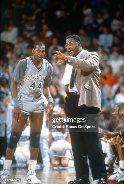 Head coach John Thompson of the Georgetown Hoyas talks with his player Ronnie Highsmith during an NCAA College basketball game circa 1988 at the...