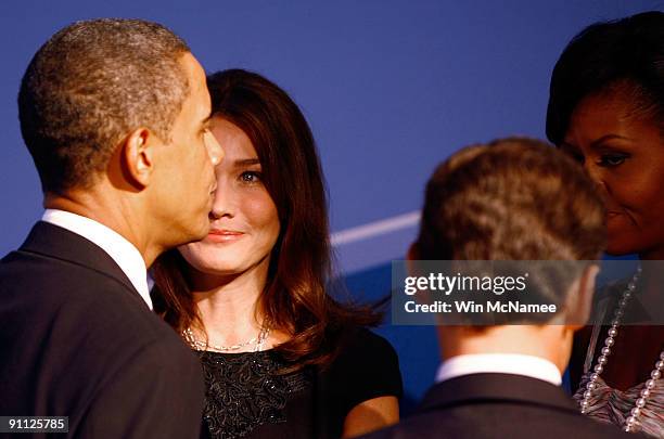 President Barack Obama talks with French President Nicolas Sarkozy and his wife Carla Bruni Sarkozy while welcoming them to the opening dinner for...