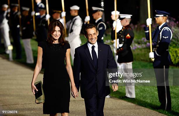 French President Nicolas Sarkozy arrives with his wife Carla Bruni Sarkozy to the welcoming dinner for G-20 leaders at the Phipps Conservatory on...