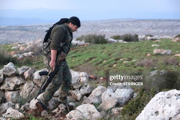 Syrian Kurdish fighter walks in the town of Rajo in the Afrin District on January 27, 2018. Turkish troops and tanks entered northern Syria on...