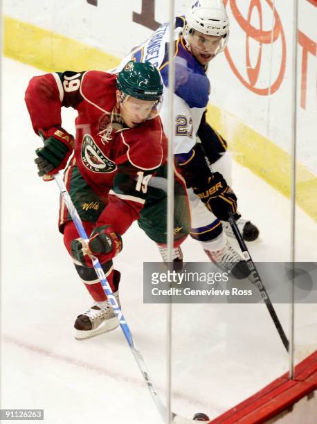 Andy Hilbert of the Minnesota Wild tries to keep the puck away from Alex Pietrangelo of the St. Louis Blues at the Xcel Energy Center on September...