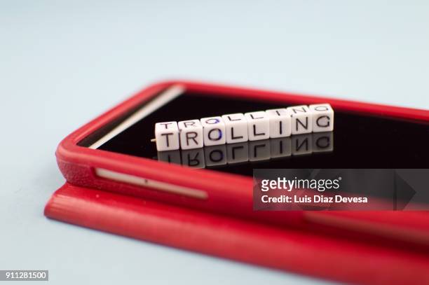 some people are using their mobile phones for making rude remarks like the trolling - addiction mobile and laptop stock-fotos und bilder