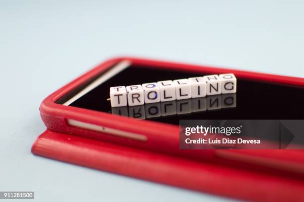 some people are using their mobile phones for making rude remarks like the trolling - addiction mobile and laptop stockfoto's en -beelden