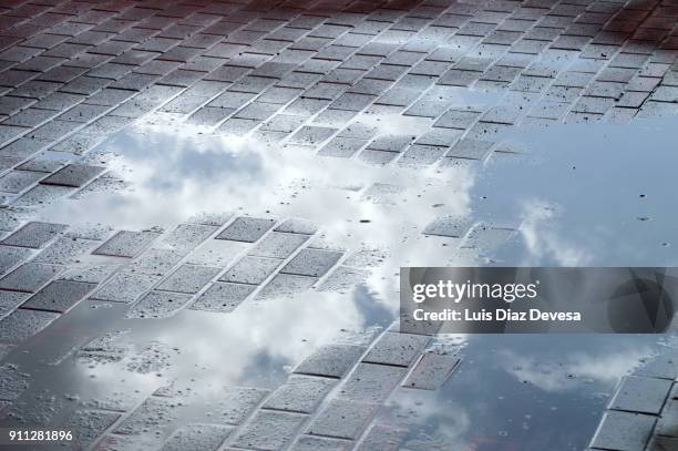 reflection in a puddle of clouds - puddle ストックフォトと画像