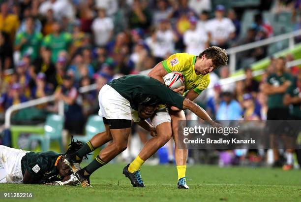 Lewis Holland of Australia is tackled in the MenÕs final match against South Africa during day three of the 2018 Sydney Sevens at Allianz Stadium on...