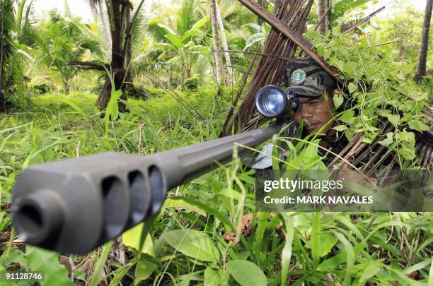 Moro Islamic Liberation Front rebel aims his .50 calibre Barret sniper rifle during a drill at camp Rajamuda in north Cotabato in Mindanao island...