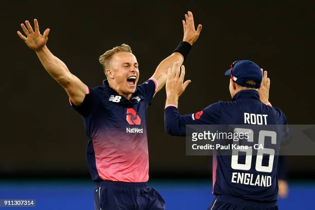 Tom Curran of England celebrates the wicket of Tim Paine of Australia with Joe Root during game five of the One Day International match between...
