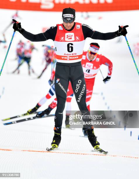 Dario Cologna of Switzerland celebrates victory crossing the finnish line ahead of runner up Alex Harvey of Canada in the Mens FIS Cross Country 15...