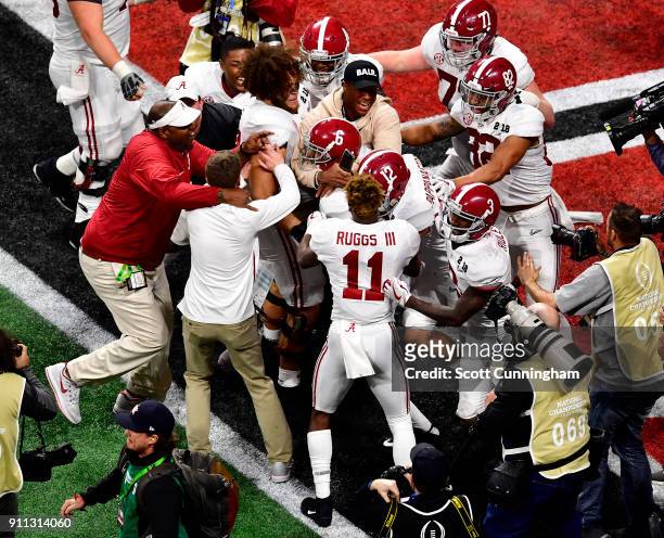 DeVonta Smith of the Alabama Crimson Tide celebrates with teammates after making the game-winning touchdown catch in overtime to defeat the Georgia...