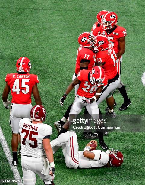 Jalen Hurts of the Alabama Crimson Tide is taunted by J. R. Reed of the Georgia Bulldogs after a tackle in the CFP National Championship presented by...