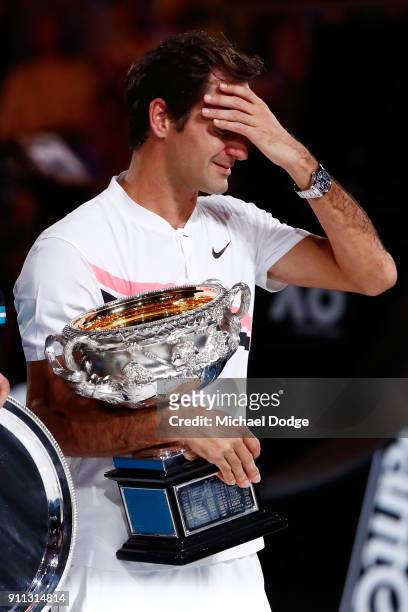 An emotional Roger Federer of Switzerland poses with the Norman Brookes Challenge Cup after winning the 2018 Australian Open Men's Singles Final...