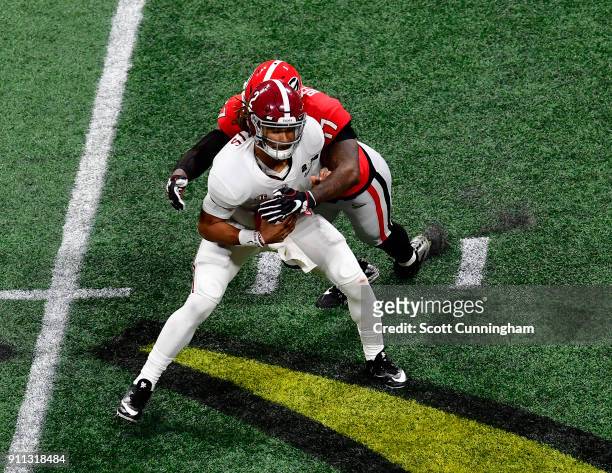 Jalen Hurts of the Alabama Crimson Tide is sacked by Davin Bellamy of the Georgia Bulldogs in the CFP National Championship presented by AT&T at...
