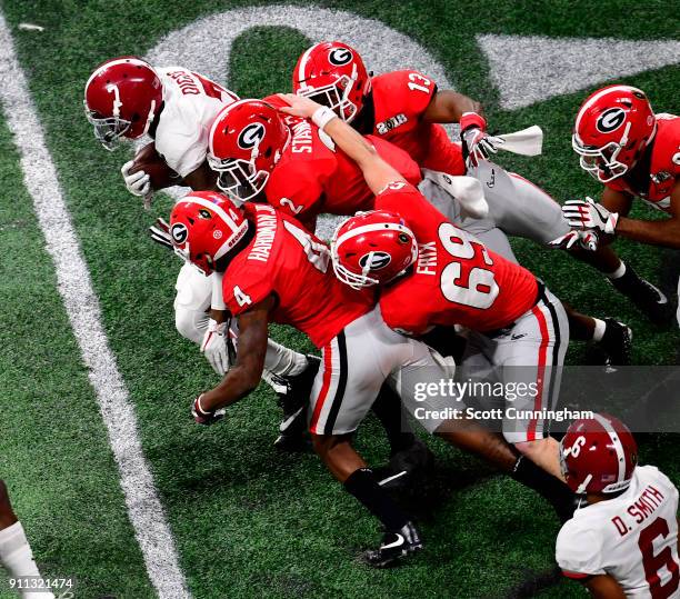 Trevon Diggs of the Alabama Crimson Tide is tackled by Richard Lecounte, Trent Frix, Jonathan Ledbetter, and Miles McGinty of the Georgia Bulldogs in...