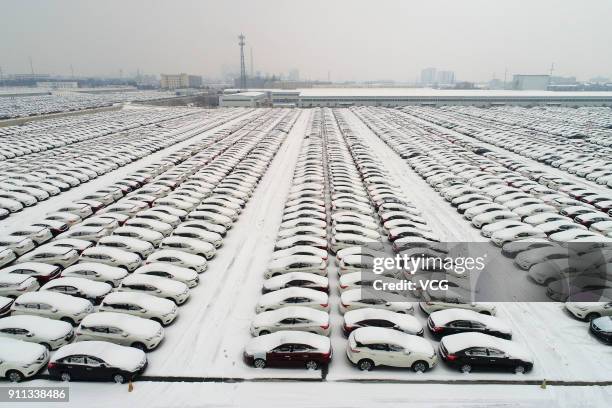 Aerial view of rows of new vehicles covered by snow at Xiangyang automobile industrial park on January 27, 2018 in Xiangyang, Hubei Province of China.