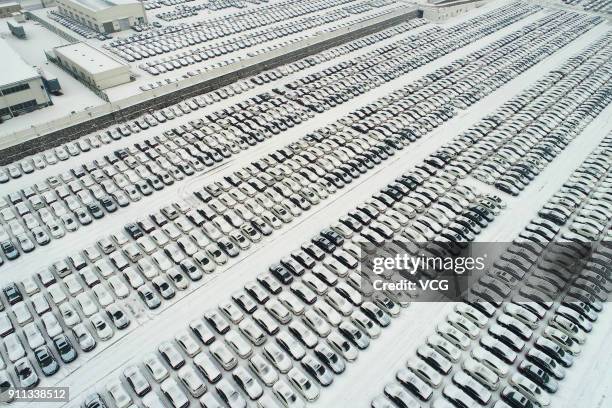 Aerial view of rows of new vehicles covered by snow at Xiangyang automobile industrial park on January 27, 2018 in Xiangyang, Hubei Province of China.