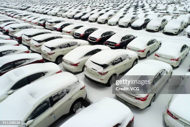 Aerial view of rows of new vehicles covered by snow at Xiangyang automobile industrial park on January 27, 2018 in Xiangyang, Hubei Province of China.