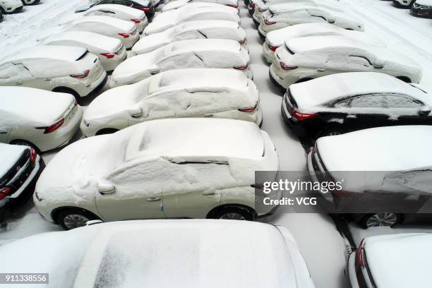 Aerial view of rows of new vehicles covered by snow at Xiangyang automobile industrial park on January 27, 2018 in Xiangyang, Hubei Province of China.