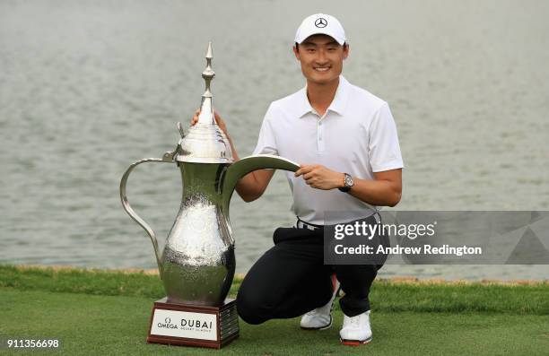 Haotong Li of China celebrates victory with the trophy after the final round of the Omega Dubai Desert Classic at Emirates Golf Club on January 28,...