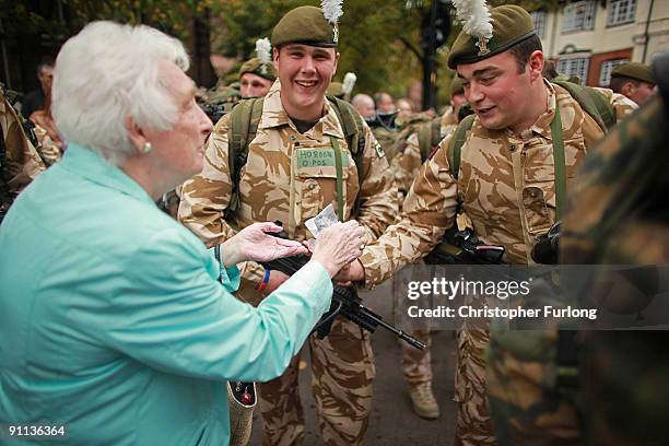 Member of the public hands out sweets to soldiers of 1st Battalion The Royal Welsh as they walk through Chester to say farewell to the city before...