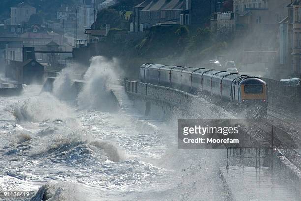 high speed train leaving dawlish in a storm - wind storm stock pictures, royalty-free photos & images