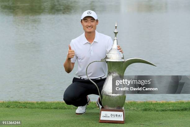 Haotong Li of China poses with the trophy after the final round of the Omega Dubai Desert Classic on the Majlis Course at Emirates Golf Club on...
