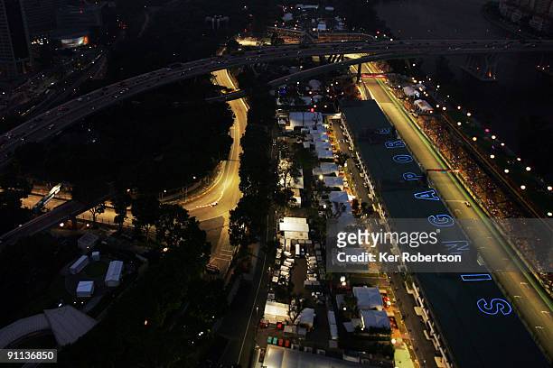 Cars drive round the illuminated track during practice for the Singapore Formula One Grand Prix at the Marina Bay Street Circuit on September 25,...