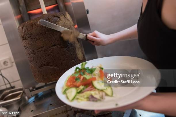 Employees prepare vegan doner plate at vegan bistro Voener on January 25, 2018 in Berlin, Germany. Voener offers classic fast food dishes such as...