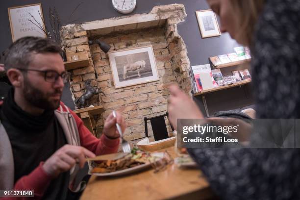 Guests eat a vegan doner plate and a doner kebab at vegan bistro Voener on January 25, 2018 in Berlin, Germany. Voener offers classic fast food...