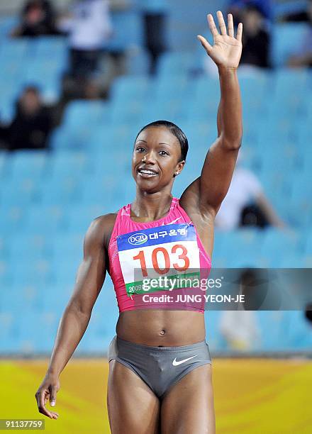 Sprinter Carmelita Jeter waves after winning the women's 100m event at the Daegu pre-championships athletics meeting in Daegu, south of Seoul, on...