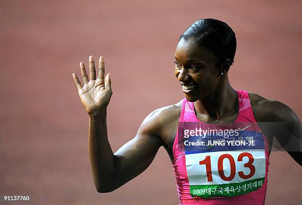 Sprinter Carmelita Jeter waves after winning the women's 100m event at the Daegu pre-championships athletics meeting in Daegu, south of Seoul, on...