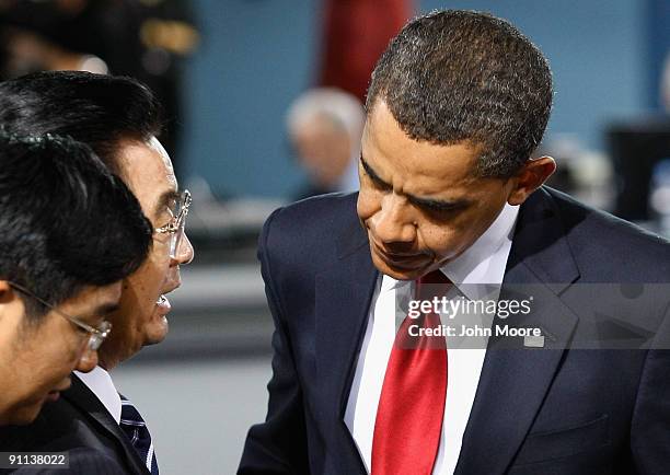 Chinese President Hu Jintao speaks with U.S. President Barack Obama at the plenary session of the G-20 summit on September 25, 2009 in Pittsburgh,...