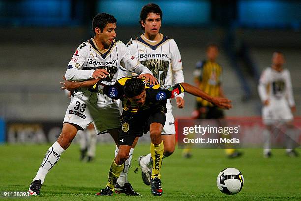 Luis Fernando Fuentes of Mexico's Pumas UNAM vies for the ball with Edder Delgado of Honduras' Real Espana during their Concacaf Champions League...