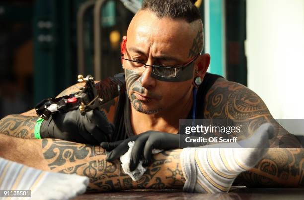 Man has his lower leg tattooed on the opening day of the fifth London Tattoo Convention held at Tobacco Dock in the east end on September 25, 2009 in...