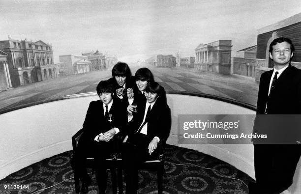 Photo of BEATLES and Brian EPSTEIN; L-R. Paul McCartney, George Harrison, John Lennon, George Harrison, Brian Epstein, receiving MBE's at Buckingham...