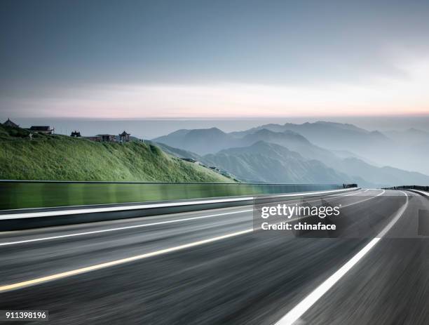 empty road travel through mountain range,blurred motion - motion blur road stock pictures, royalty-free photos & images