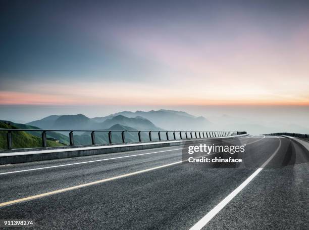 viaggio su strada vuoto attraverso la catena montuosa - empty road foto e immagini stock