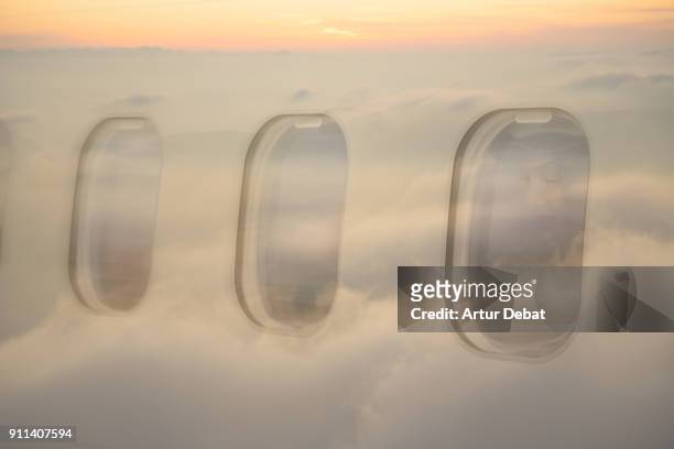 creative double exposure composition picture of traveler woman looking through window with sunset view reflected on airplane with picture taken from outside of airplane arriving to the destination airport. - airplane window exterior stock-fotos und bilder