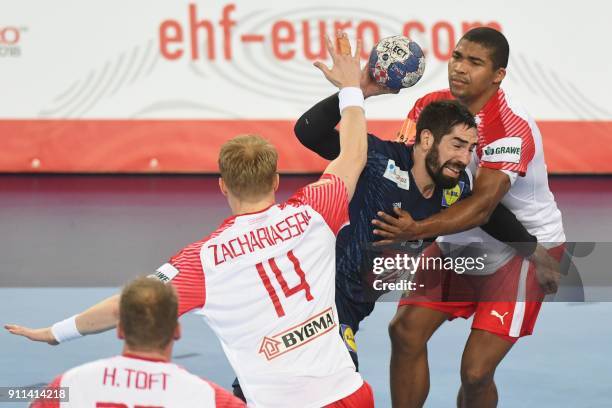 Denmark's Mads Mensah Larsen and Denmark's Anders Zachariassen hold off France's Nikola Karabatic during the match for third place of the Men's 2018...