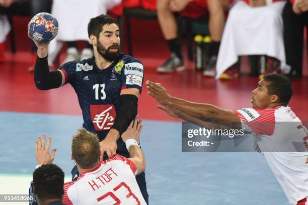 France's Nikola Karabatic passes the ball under pressure from Denmark's Henrik Toft Hansen and Denmark's Mads Mensah Larsen during the match for...