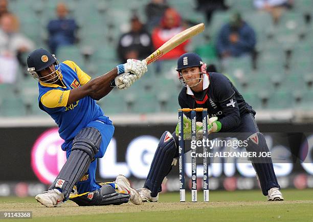 Sri Lankan cricketer Angelo Mathews swings at a shot off bowled by English Graeme Swann as England wicketkeeper Matt Prior looks on during the ICC...