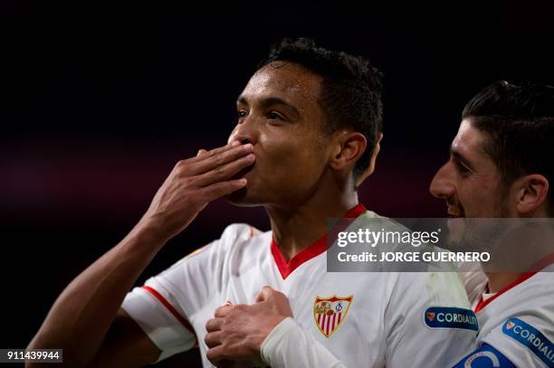 Sevilla's Colombian forward Luis Muriel blows a kiss as he celebrates a goal with defender Sergio Escudero during the Spanish league football match...