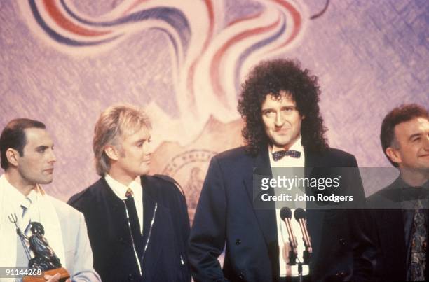 Photo of QUEEN, L- R Freddie Mercury, Roger Taylor, Brian May and John Deacon on stage at the Brit Awards