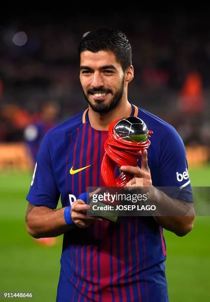 Barcelona's Uruguayan forward Luis Suarez poses with his Best Player of the Month award before the Spanish league football match between FC Barcelona...