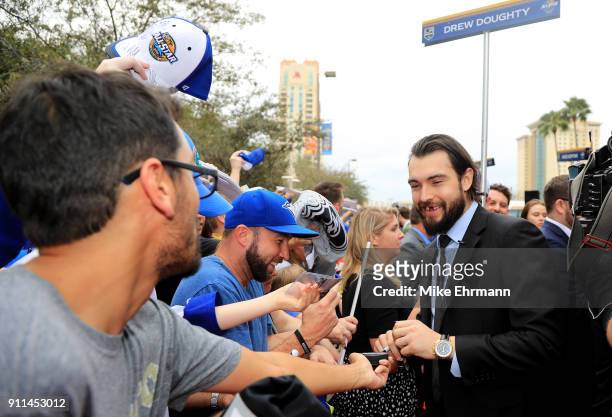 Drew Doughty of the Los Angeles Kings signs autographs after arriving on the red carpet prior to the 2018 Honda NHL All-Star Game at Amalie Arena on...