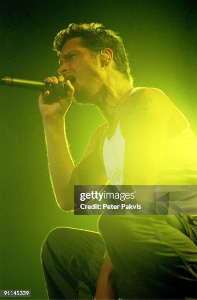 Photo of AUDIOSLAVE; Audioslave, Nederland, Heineken M H, A'dam, 15 juni 2005, Pop, metal, rock, zanger Chris Cornel zingt zittend op zijn hurken met...