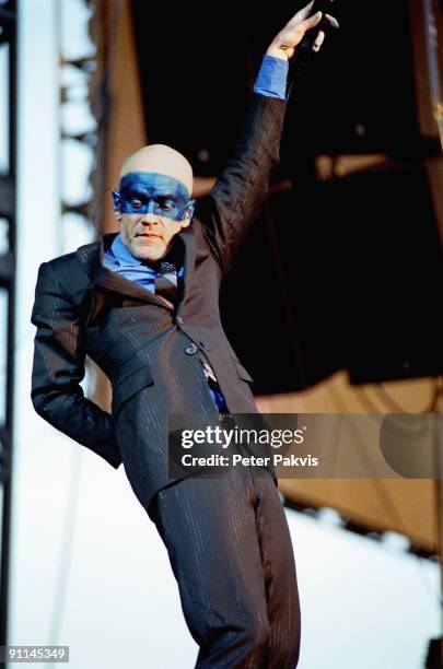 Photo of REM, REM, Nederland, Rockin' Park, Nijmegen, 26 juni 2005, Pop, wave, Micheal Stipe, wiens gelaat gedeeltelijk is be-, schilderd met blauwe...