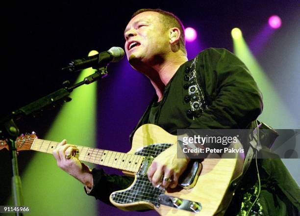 Photo of UB40; UB 40, Nederland, H M H, Amsterdam, 26 maart 2005, Pop, reggae, de zanger zingt en speelt op zijn gitaar, achtergrond zijn mooie...