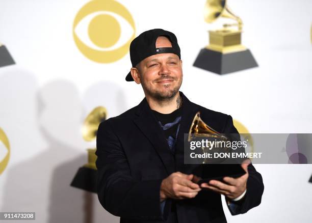 Residente holds the trophy for Best Latin Rock album in the press room during the 60th Annual Grammy Awards on January 28 in New York. / AFP PHOTO /...